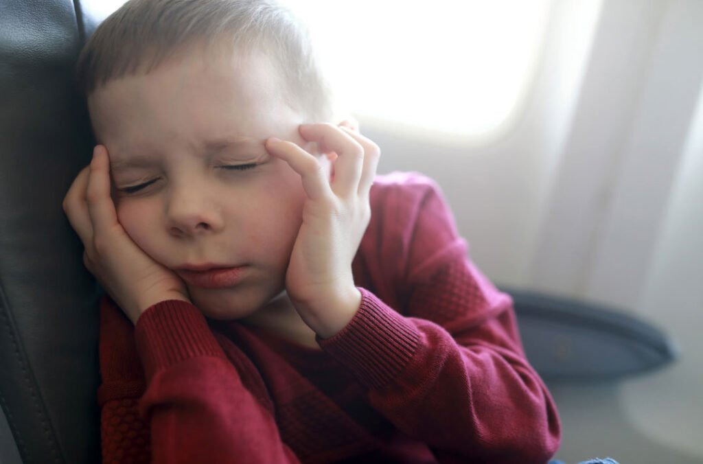 Criança no avião sentindo dor de ouvido